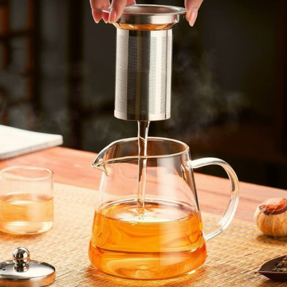 main retirant infuseur de la théière en verre