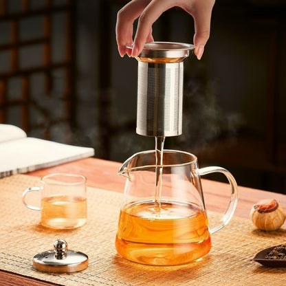 main retirant infuseur de la théière en verre