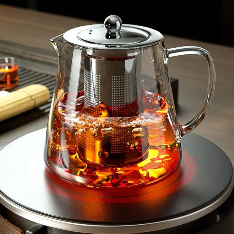 théière en verre avec thé infusé sur une plaque chauffante