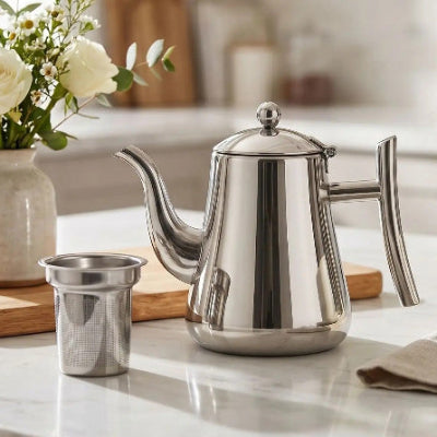 Théière inox et passoir sur un comptoir